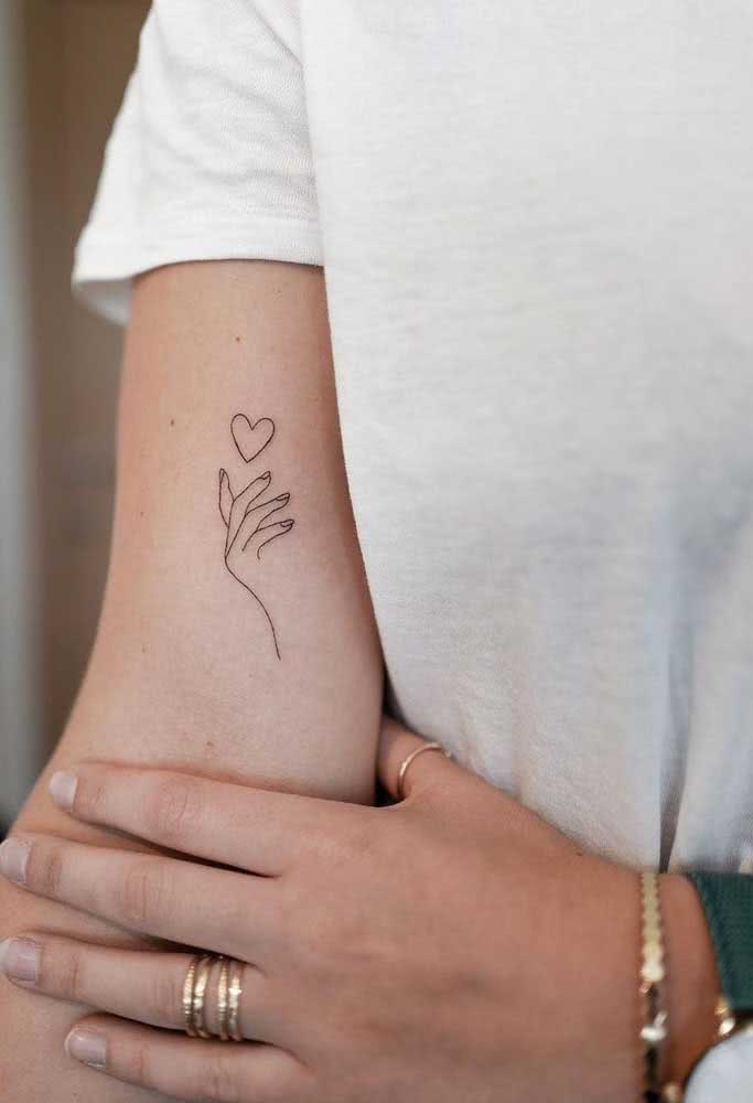 Mãos femininas com tatuagem no sofá em casa relaxante mão de tatuagem de  mulher